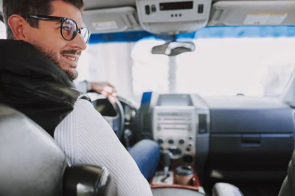 Lächelnder Kaukasier mit Brille sitzt in seinem neuen Auto — Stockfoto