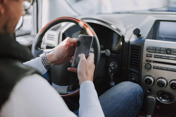 Kaukasier sitzt im Auto und tippt Nachricht — Stockfoto