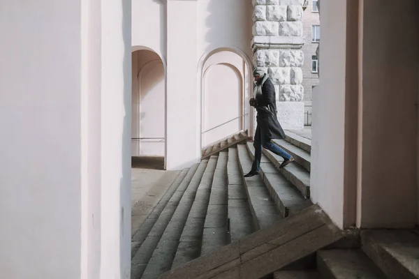 Kaukasischer Typ im Mantel geht auf Treppe — Stockfoto