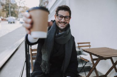 Gözlüklü beyaz erkek işçi dışarıda eğleniyor.