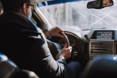 Beyaz bir genç adam araba kullanıyor.