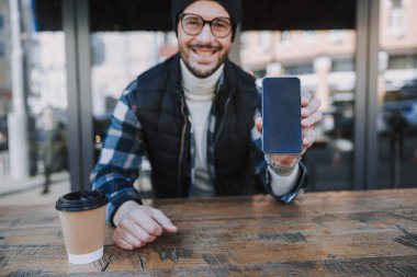 Mutlu adam cep telefonunu dışarıda tutuyor.