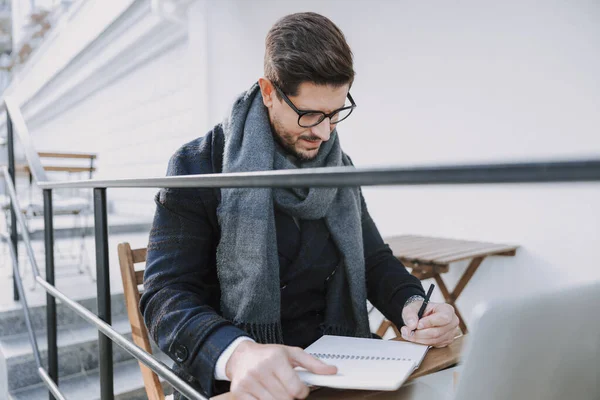 Caucasien concentré homme prend des notes à l'extérieur — Photo