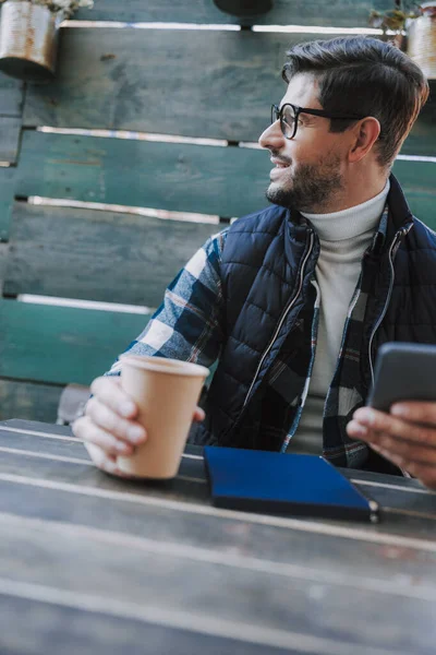 Uśmiechnięty biały mężczyzna pije kawę na zewnątrz. — Zdjęcie stockowe