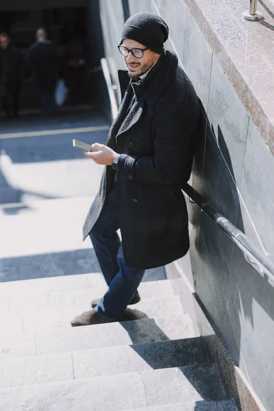 Uomo attraente caucasico appoggiato al muro sulle scale — Foto Stock