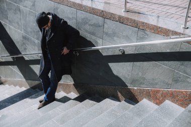 Kafkas sakallı adam cebine cep telefonu koyuyor.