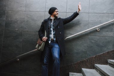 Kafkasyalı mutlu adam dışarıda birine gülümsüyor.