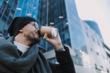 Beyaz erkek dışarıda lezzetli içkisinin tadını çıkarıyor.