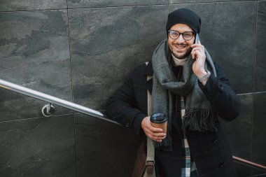 Beyaz, kalın elbiseli, içecek içen adam.