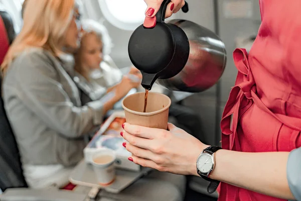 Хозяйка самолета готовит кофе для пассажиров — стоковое фото
