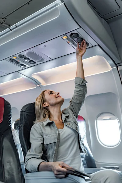 Feliz dama está sentada cerca de la ventana en el avión —  Fotos de Stock