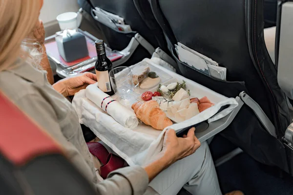 Молодая женщина сидит в самолете с едой — стоковое фото