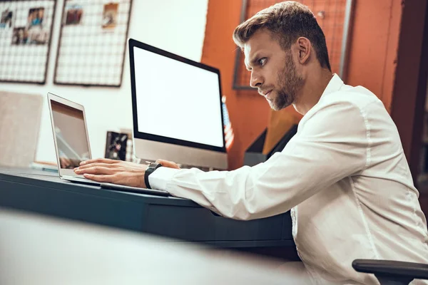 Ocupado trabajador masculino está buscando en la pantalla del ordenador portátil —  Fotos de Stock