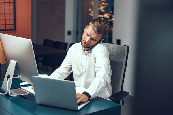 Jeune homme assis au bureau avec des gadgets modernes — Photo