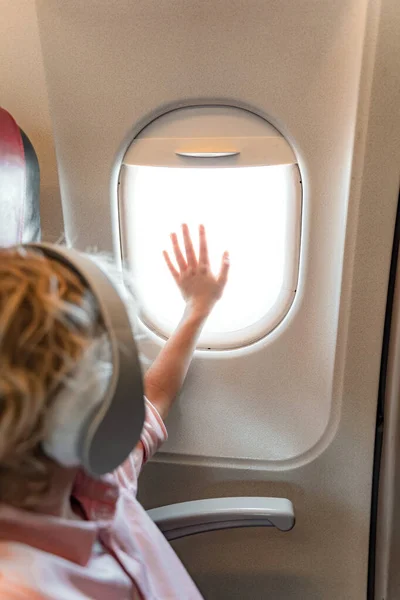 Kind zit bij het raam in het vliegtuig — Stockfoto