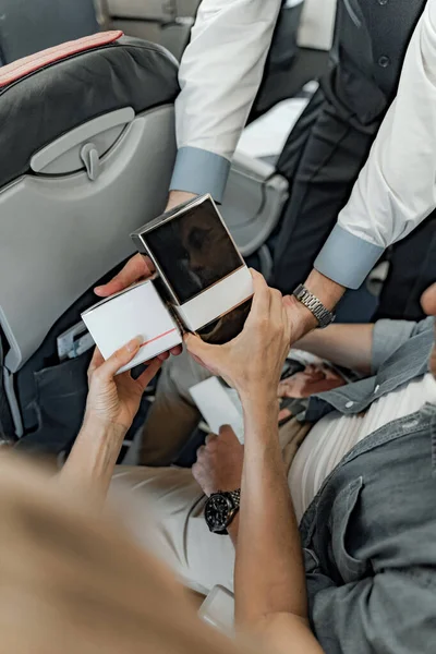 Asistente de vuelo está mostrando perfume para mujer en cabina — Foto de Stock