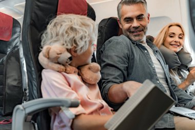 Gülümseyen küçük robot kulübede kitap okuyor.