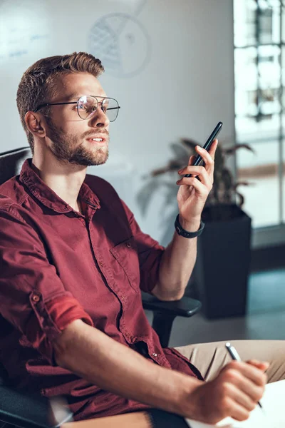 Jovem de óculos com telefone celular — Fotografia de Stock