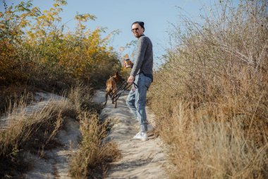 Kahveli ve tasmalı bir adam.