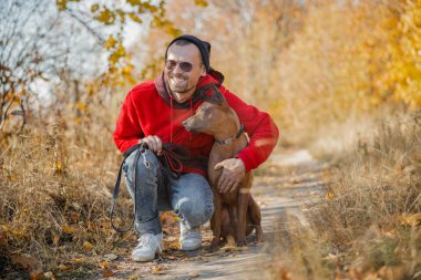 Güzel köpek stoğu fotoğrafının yanında çömelmiş mutlu adam.