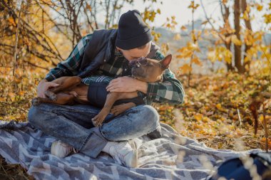 Köpeği öpen ve gözlük takan bir adam.