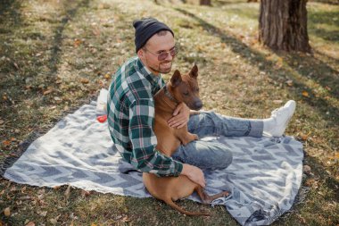Mutlu adam ormanda köpekle eğleniyor.