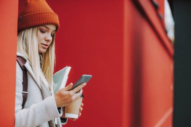 Genç kız öğrenci modern akıllı telefon kullanıyor.