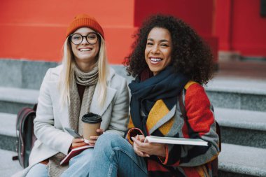 Üniversitenin yanında oturan Kafkasyalı ve Afro Amerikalı genç kızlar