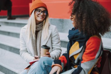 Genç Kafkasyalı ve Afro Amerikalı kadınlar açık havada birlikte