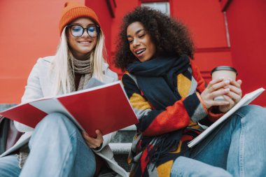 Fotokopi defterine bakan Kafkas ve Afro Amerikalı genç kadınlar