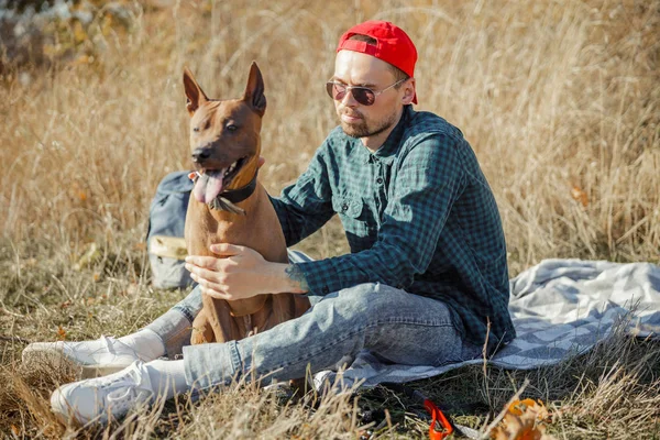 Ruhiger Mann entspannt beim Picknick mit seinem Haustier Archivfoto — Stockfoto