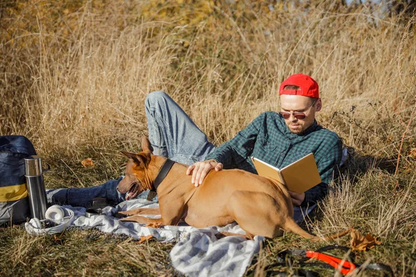 Sahibi köpekle rahatlıyor ve resimlere bakıyor.