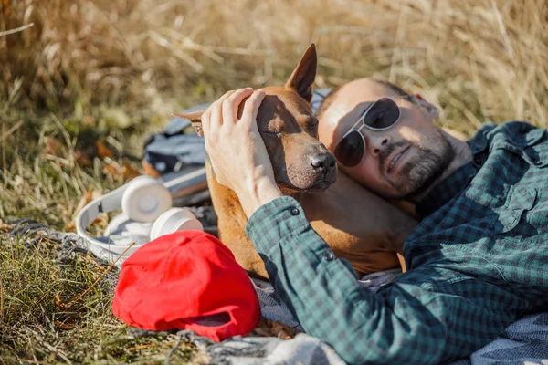 Propietario acostado con el perro y darle palmaditas foto de stock — Foto de Stock