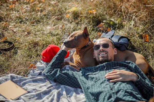 Happy dog owner enjoying sunny day outdoors stock fotky — Stock fotografie