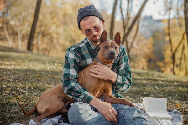 Besitzer in Brille sitzt mit seinem Haustier Archivfoto — Stockfoto