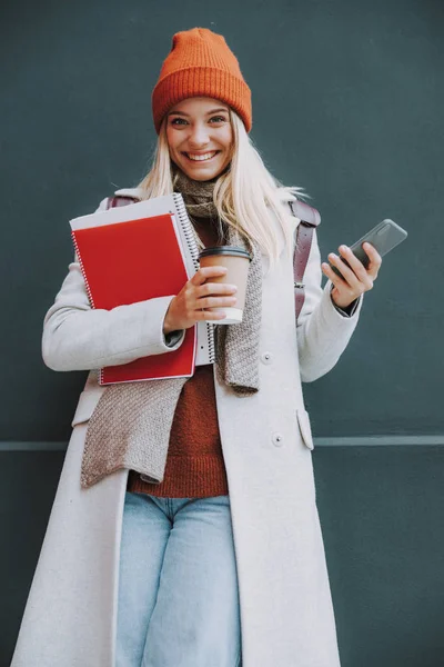 Giovane studentessa con caffè vicino alla parete — Foto Stock