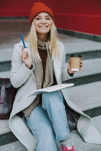 Csinos női diák tollal és kávéval. — Stock Fotó