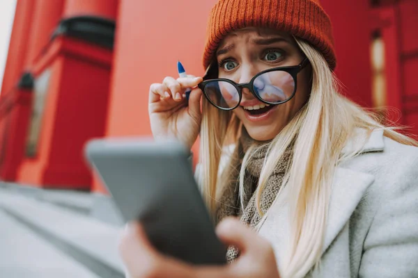 女子学生女の子見ますの現代的なスマートフォン — ストック写真