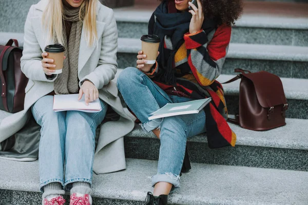 Mujeres caucásicas y afroamericanas sentadas al aire libre — Foto de Stock