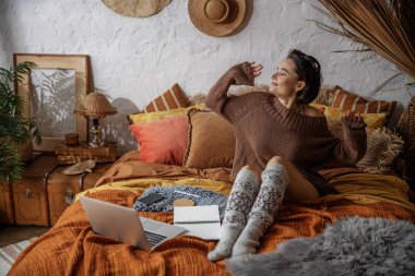 Güzel kadın odada yatakta geriniyor.