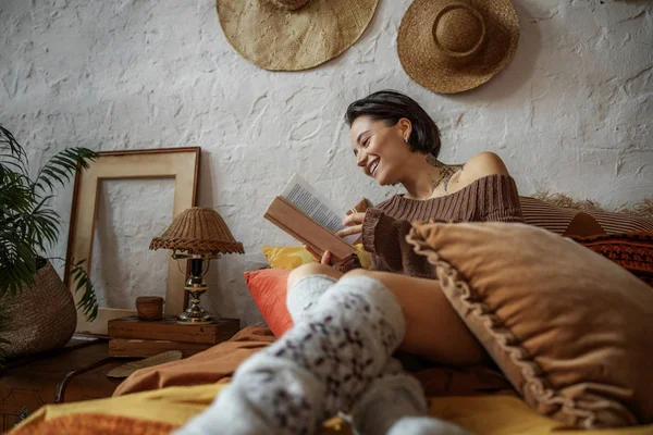 Ευτυχισμένη κυρία απολαμβάνει ενδιαφέρον βιβλίο στην κρεβατοκάμαρα — Φωτογραφία Αρχείου