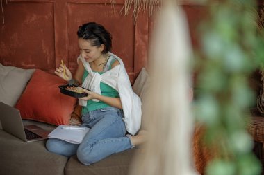 Gülümseyen genç bayan yemeğine bakıyor.