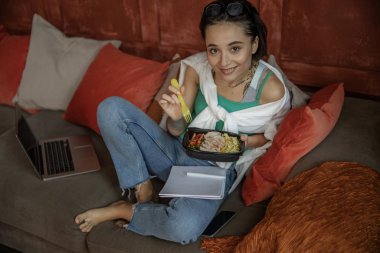 Mutlu bayan evde yemekle poz veriyor.