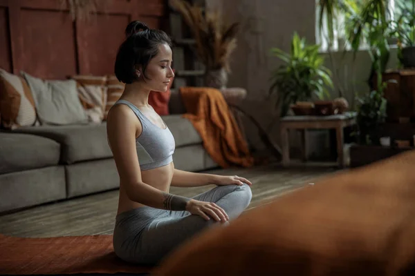 Vacker ung kvinna som utövar yoga hemma — Stockfoto
