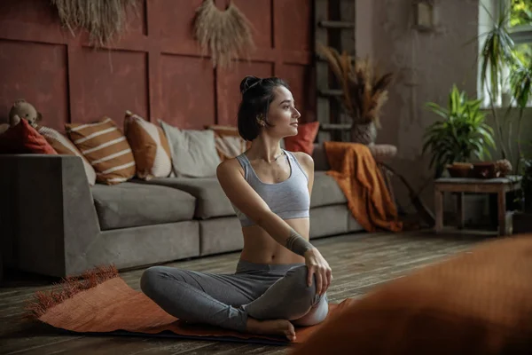 Attraktive Dame praktiziert ihre Yoga-Routine zu Hause — Stockfoto