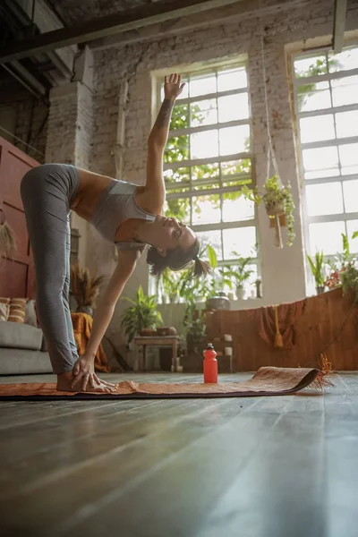 Hübsche junge Frau macht Yoga-Übungen zu Hause — Stockfoto