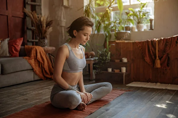 Hübsche Frau meditiert beim Yoga zu Hause — Stockfoto