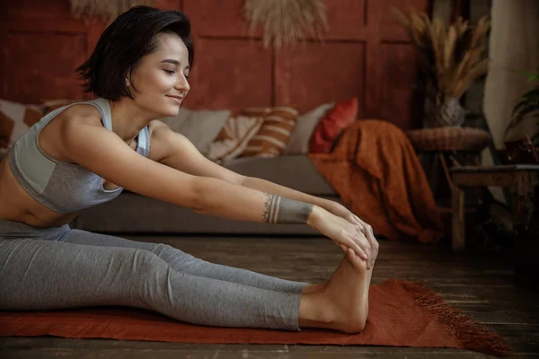 Mulher é alongamento e meditação em casa — Fotografia de Stock