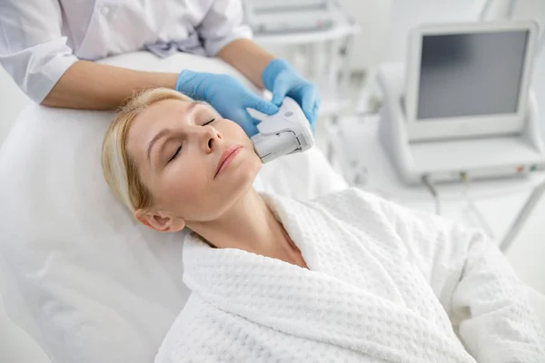 Adult woman with closed eyes during lifting — Stock Photo, Image