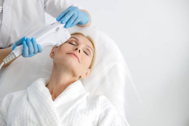 Yüz gerdirme sırasında gözleri kapalı mutlu bir kadın.